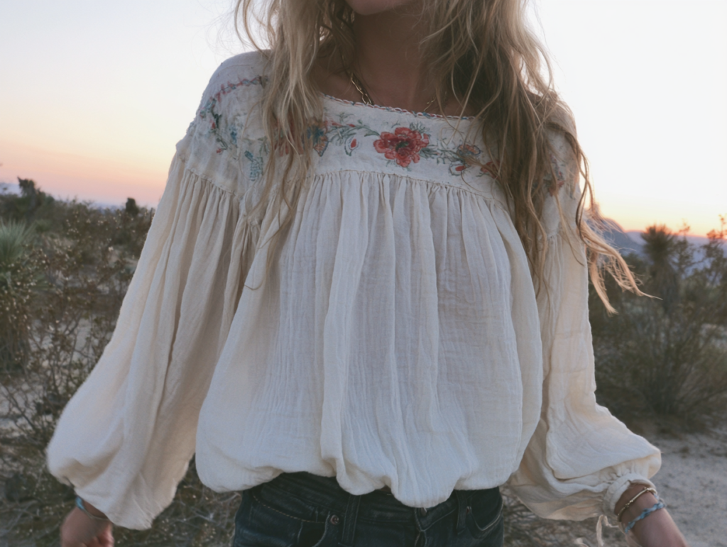 Cream boho peasant blouse with floral embroidery and balloon sleeves in desert sunset, women's flowy top.