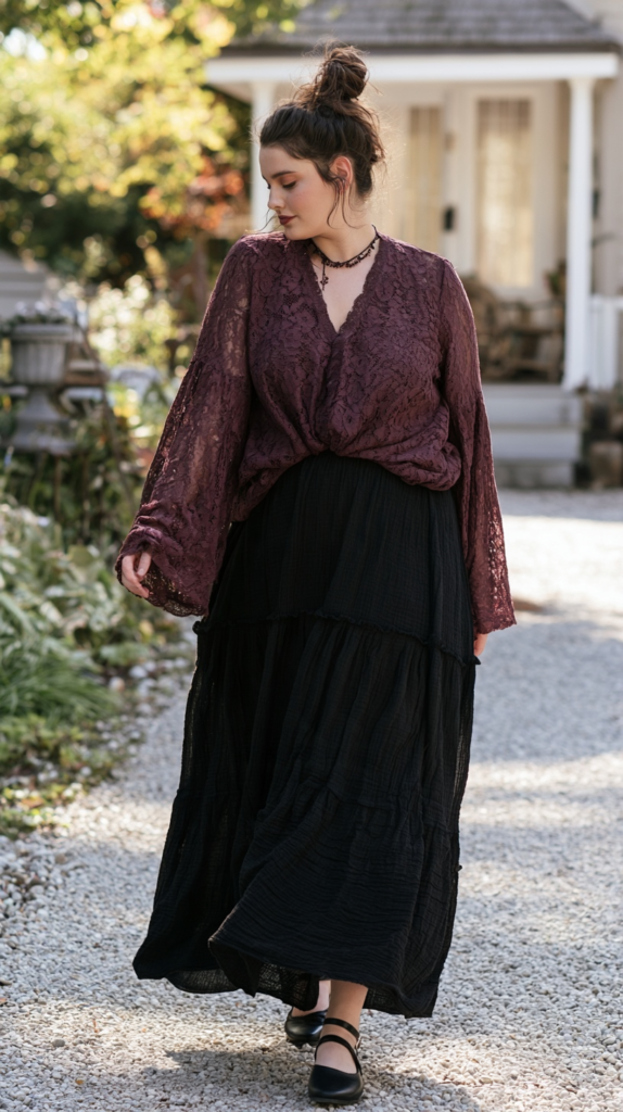 Woman in plum lace blouse and black tiered maxi skirt walking on a gravel path, boho fall outfit